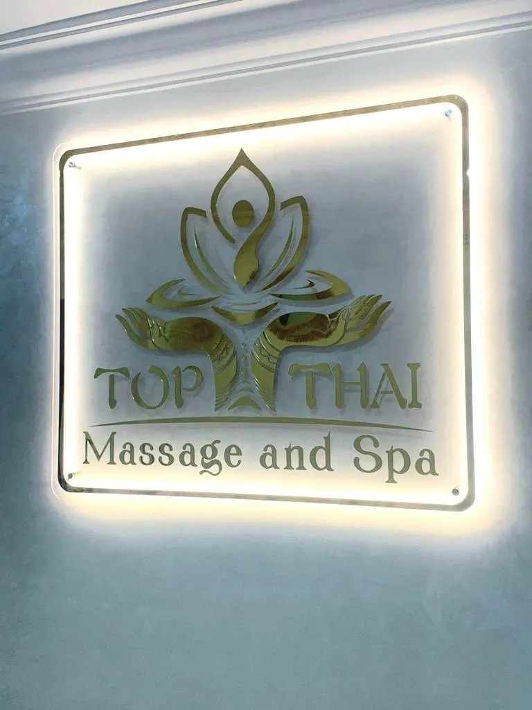 L’enseigne lumineuse Top Thai Massage and Spa, à l’intérieur, près de l’accueil