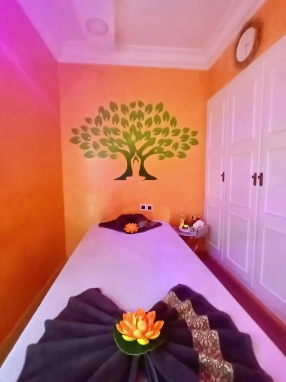 Salle de soin au mur orange, décor d’arbre de vie
