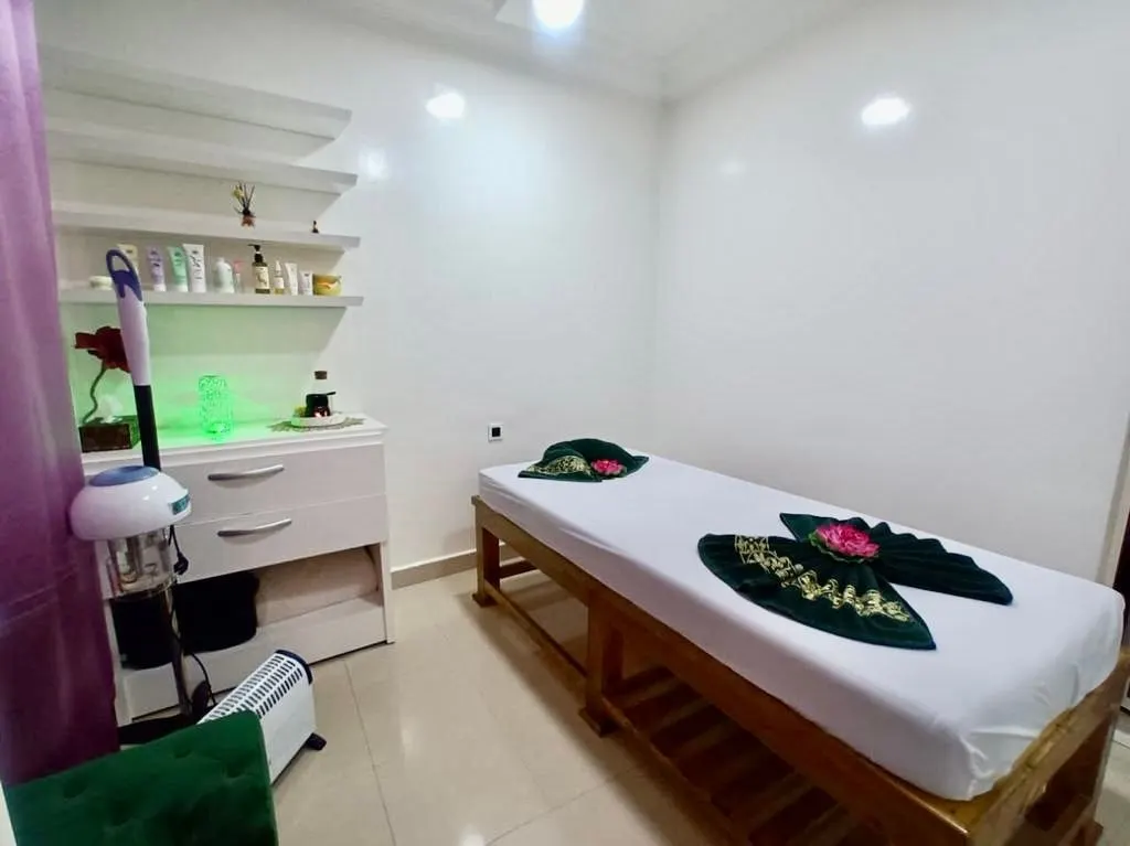 Salle de soin avec un vaporisateur visage et une serviette verte en éventail